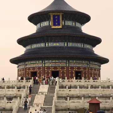 Round triple-roofed wooden hall with blue tiles on white marble terraces, crowds of visitors, Temple of Heaven, Beijing.