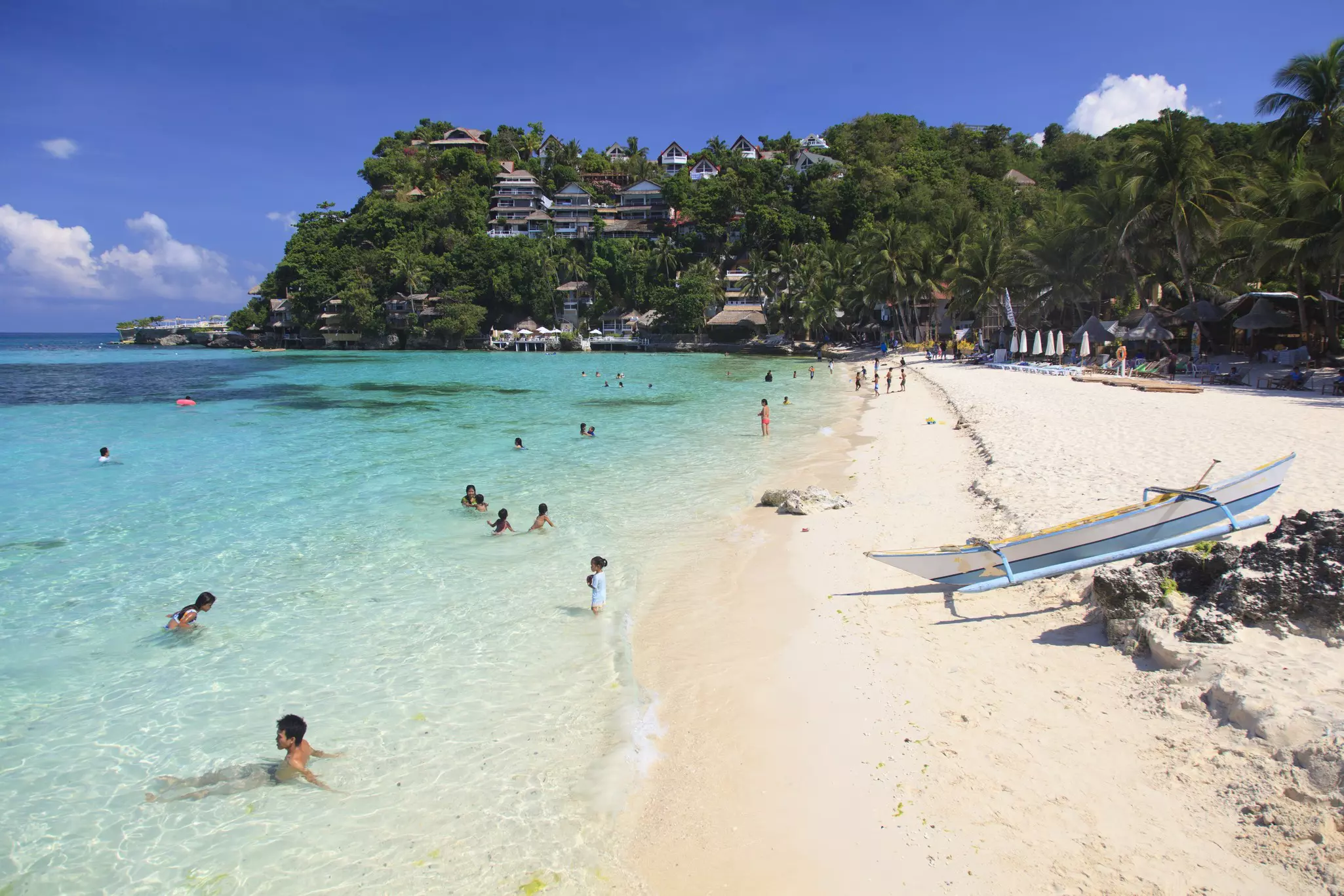 People enjoying the white sands of Boracay Island in the Philippines.