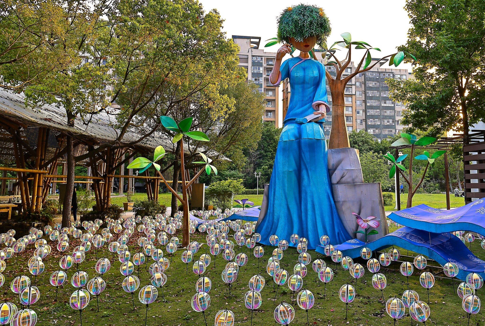 Art installation of a large seated figure in blue in a field of orbs at the Taipei City Hakka Cultural Park.