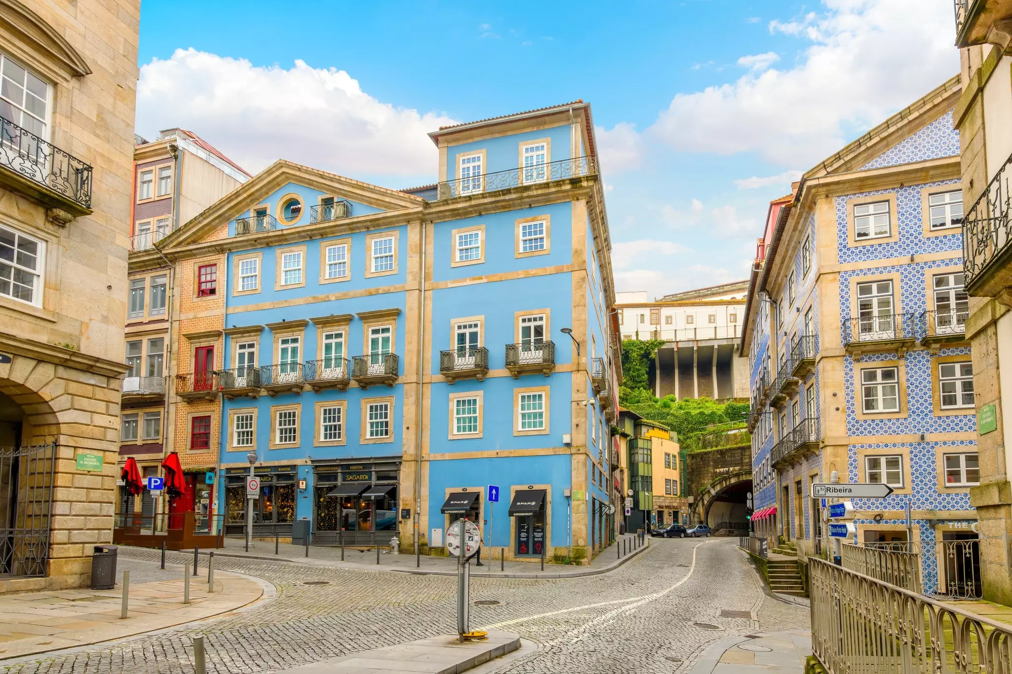 Colorful buildings along a cobblestone street on a sunny day.