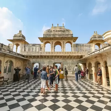 Tourists sightseeing Udaipur City Palace medieval architecture structure built in the year 1553 in Rajasthan, India.