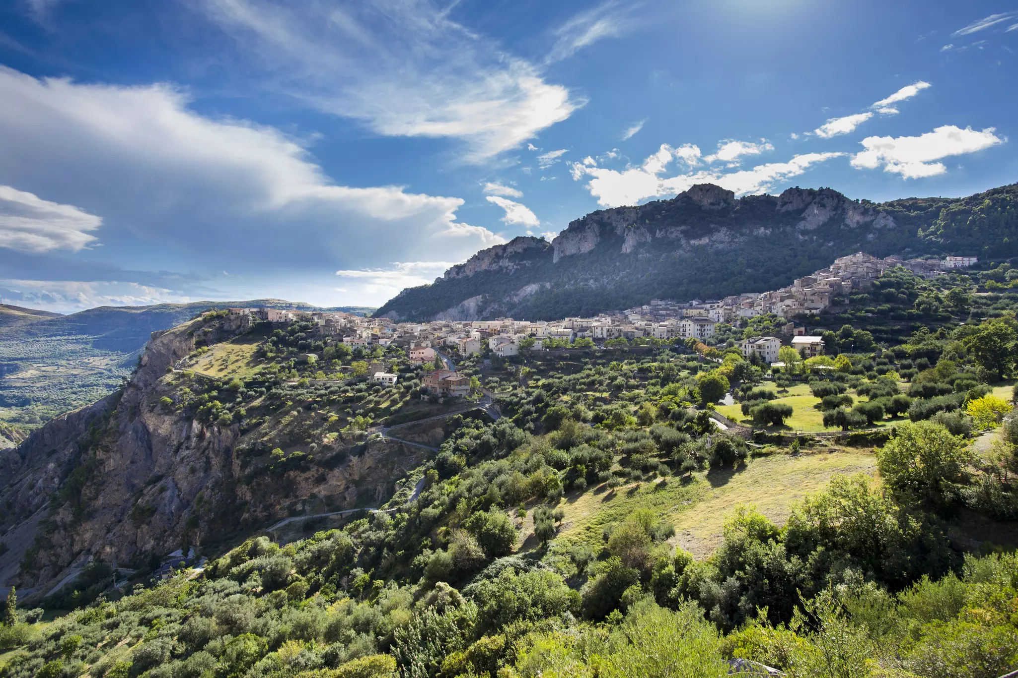A village of low-rise buildings tucked between mountain peaks in a rural area.