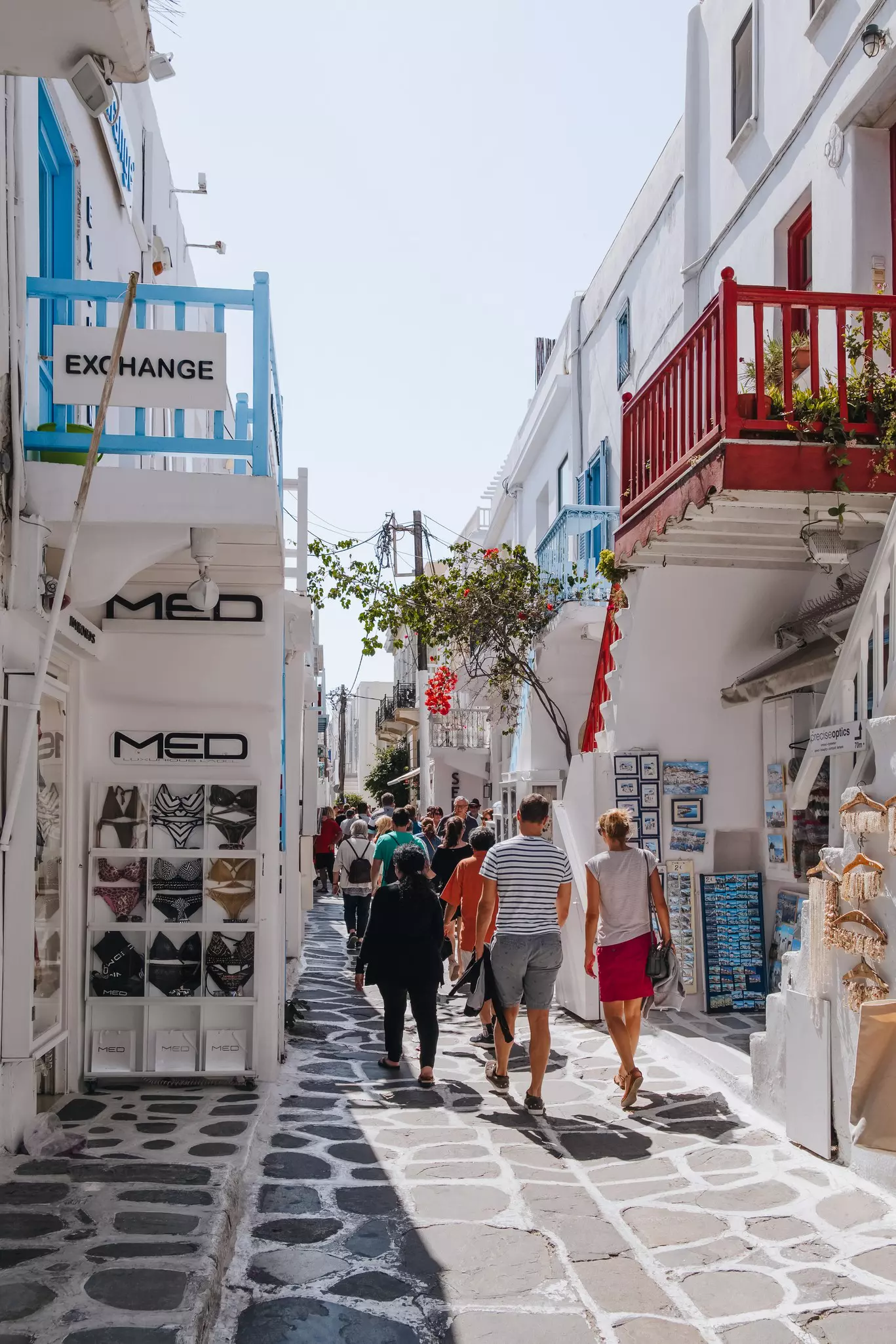 People wander down a narrow street in Mykonos Town (Hora) browsing the many shops and boutiques.