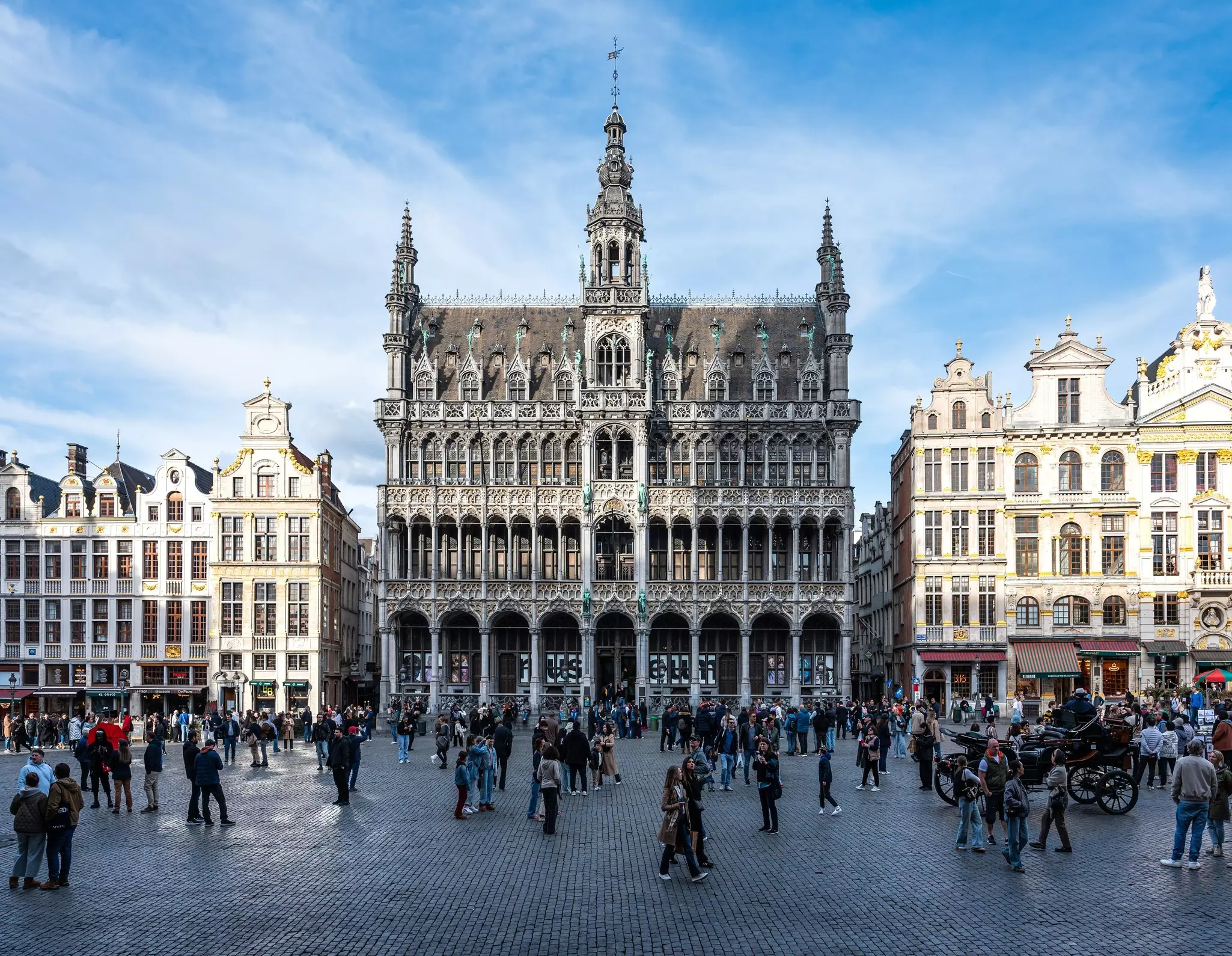 People milling in front of the facade of the Museum of the City of Brussels at Grand Place,  Brussels city center, Belgium