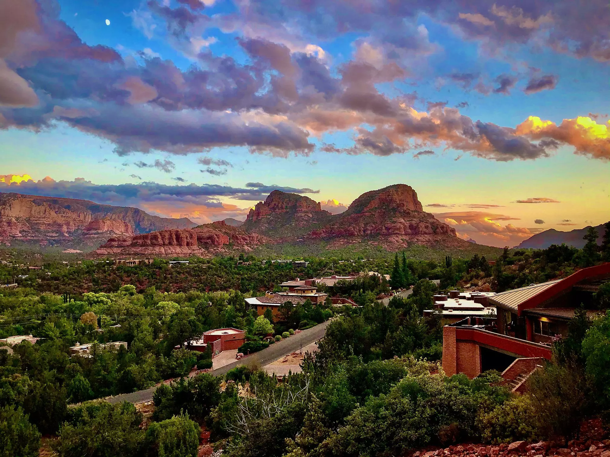 An aerial view of a desert city with a sunset above