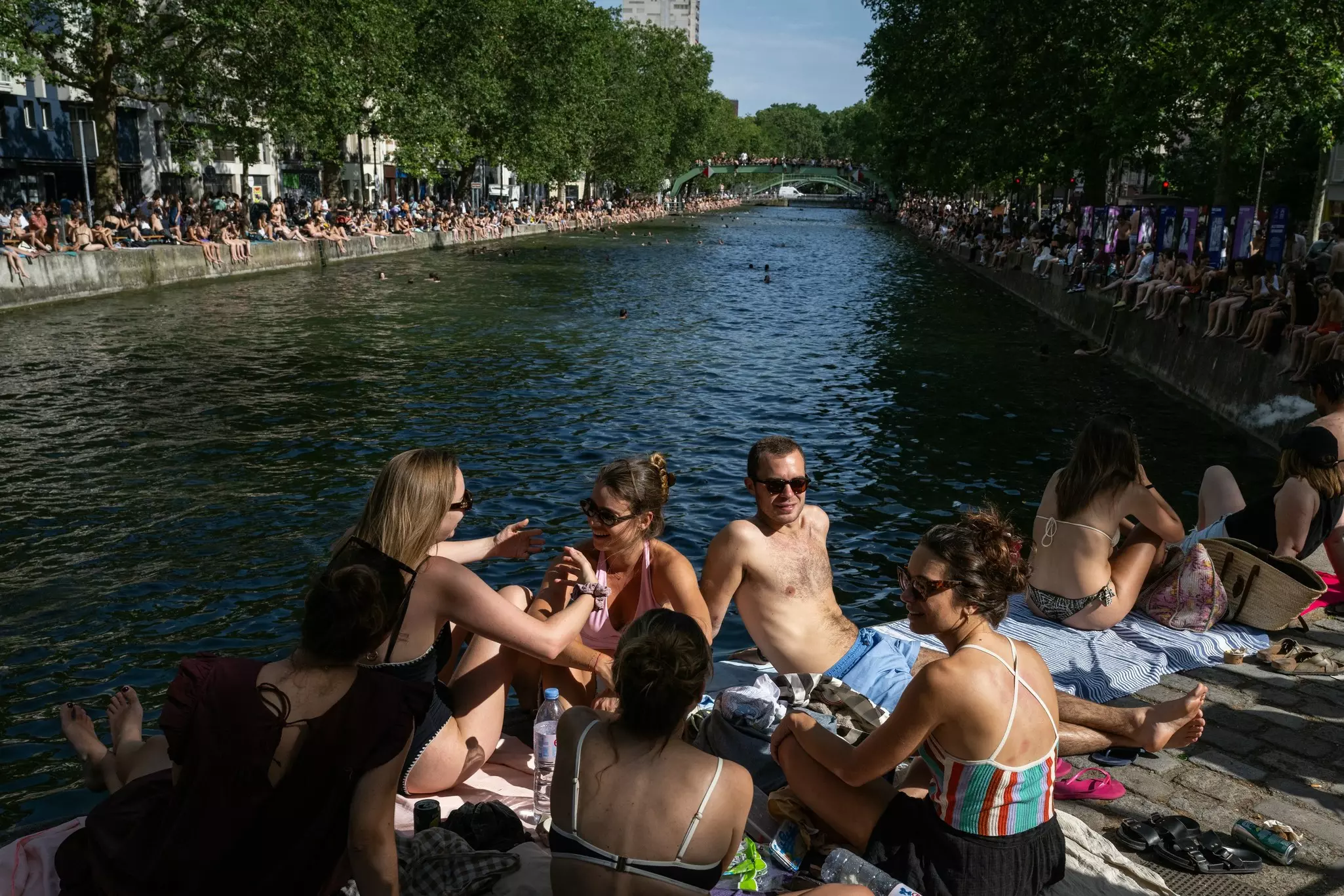 People sunbathe by the Canal Saint-Martin during the Paris heatwave on 2026, France.