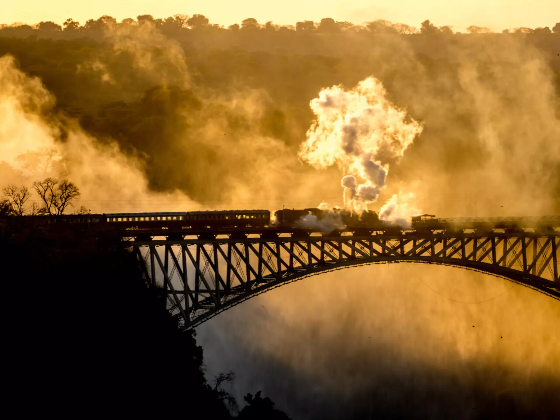 Steam Train driving over Steel Bridge at Victoria Falls  License Type: media  Download Time: 2023-07-10T15:54:35.000Z  User: nic.dhoedt_lonelyplanet  Is Editorial: No  purchase_order: