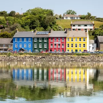 Vibrant colours and reflections in the water make this a scenic view of a popular town on the Wild Atlantic Way. Bantry, County Cork, Ireland. Colorful reflection of a row of houses.