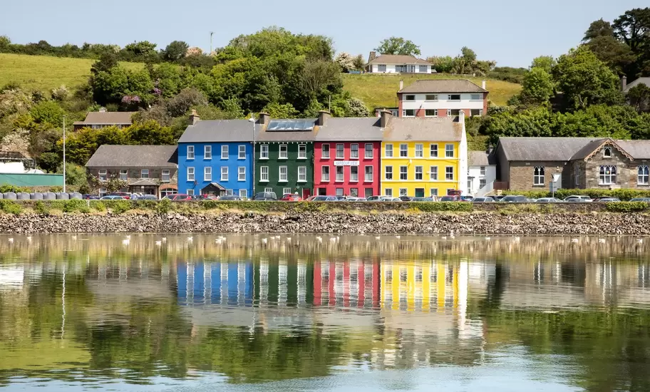 Vibrant colours and reflections in the water make this a scenic view of a popular town on the Wild Atlantic Way. Bantry, County Cork, Ireland. Colorful reflection of a row of houses.