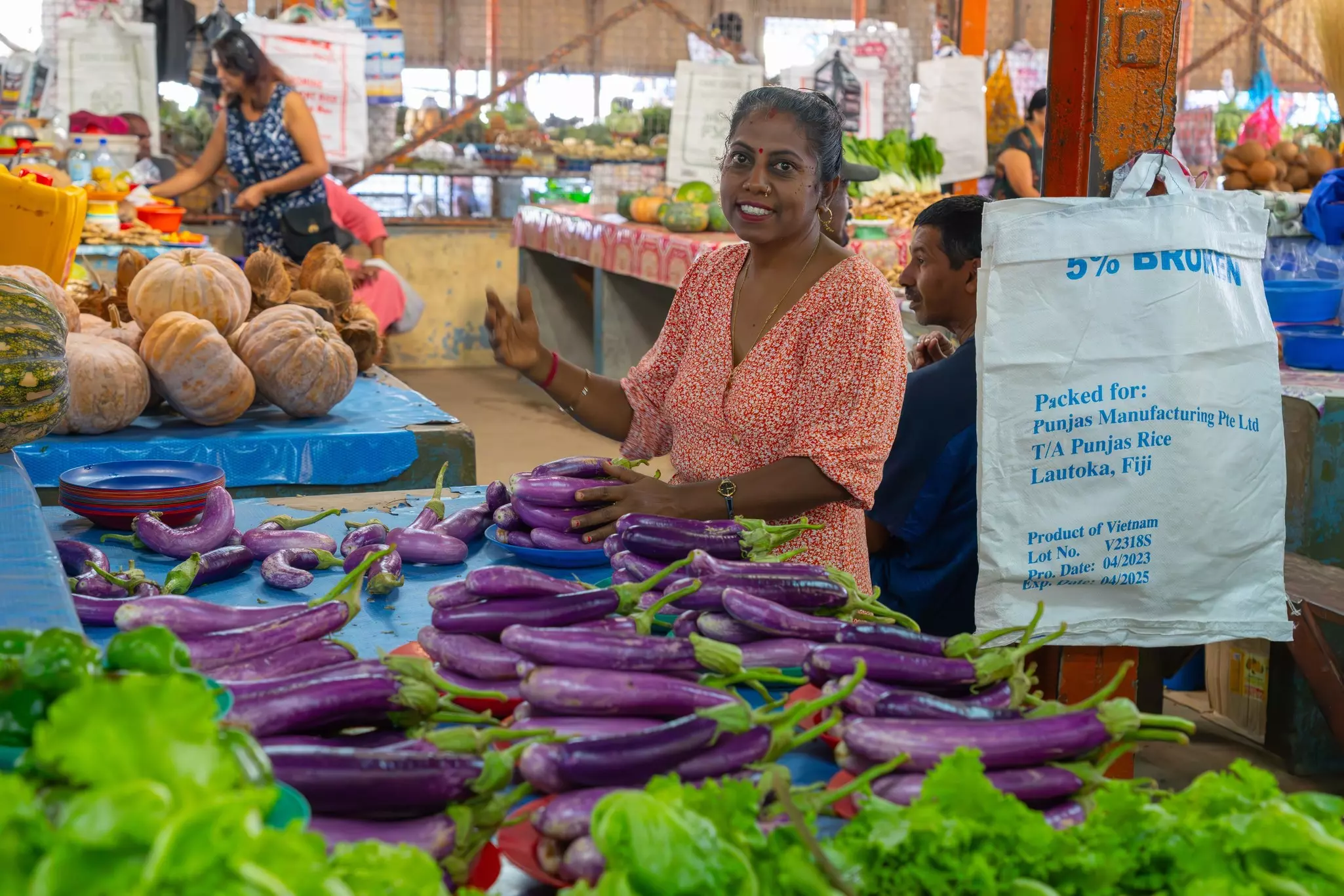 People at a farmers market with colorful produce on display
