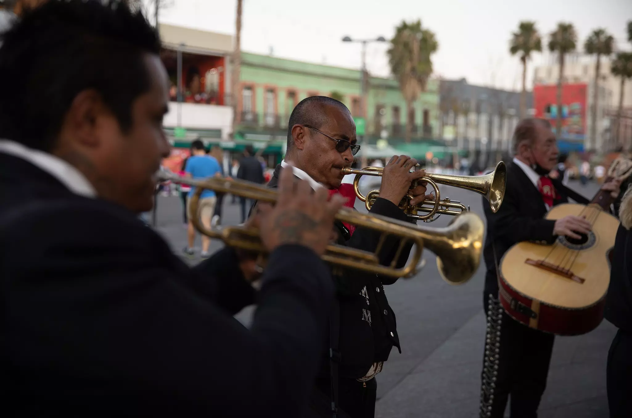 A close-up shot of mariachi musicians performing in a city square.