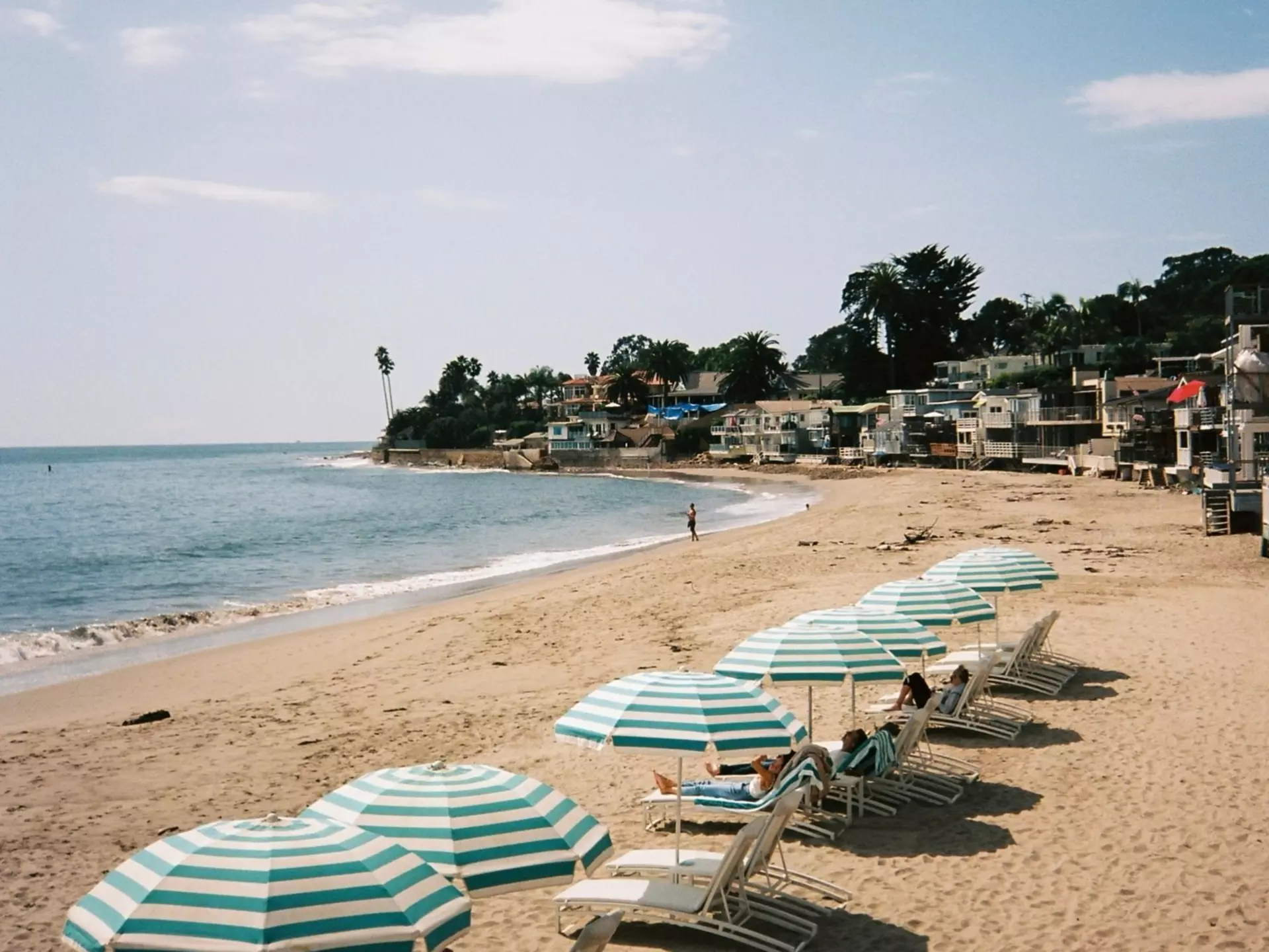 Relaxing beach chairs and umbrellas on the sand of a California beach. Blue and white striped umbrellas in Santa Barbara, California. Hotel beach club luxury., License Type: media, Download Time: 2026-04-08T16:09:46.000Z, User: LP_LHorst, Editorial: false, purchase_order: 56530 - Guidebooks, job: Editorial Photo, client: USA Roadtrips 6, other: Lyn Horst