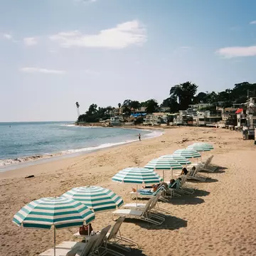 Relaxing beach chairs and umbrellas on the sand of a California beach. Blue and white striped umbrellas in Santa Barbara, California. Hotel beach club luxury., License Type: media, Download Time: 2026-04-08T16:09:46.000Z, User: LP_LHorst, Editorial: false, purchase_order: 56530 - Guidebooks, job: Editorial Photo, client: USA Roadtrips 6, other: Lyn Horst