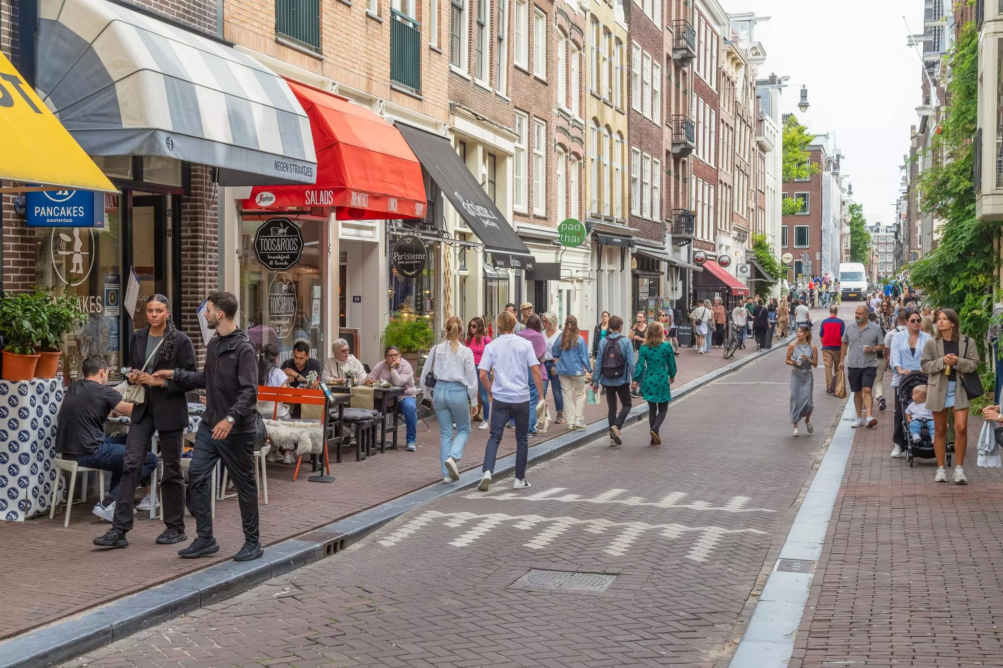 People wandering down a shop-lined street