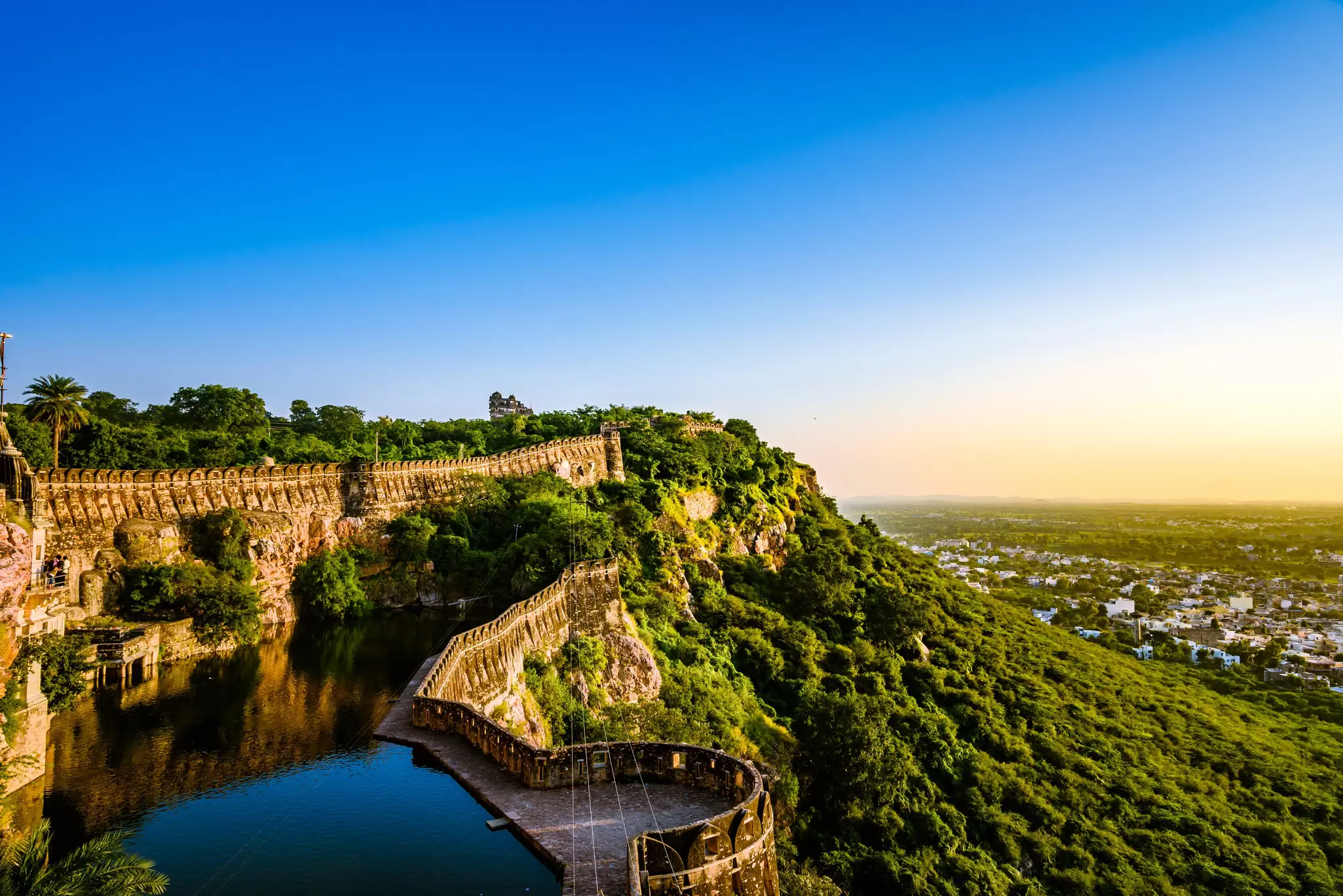 Aerial view over Chittorgarh Fort and the surrounding city during sunset in Rajasthan, India.