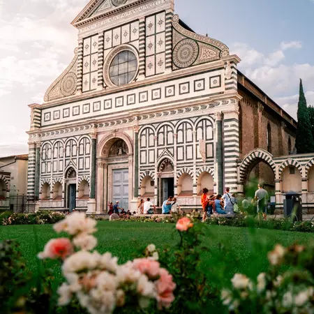 The facade of a Renaissance church. Flowers are seen in the foreground.