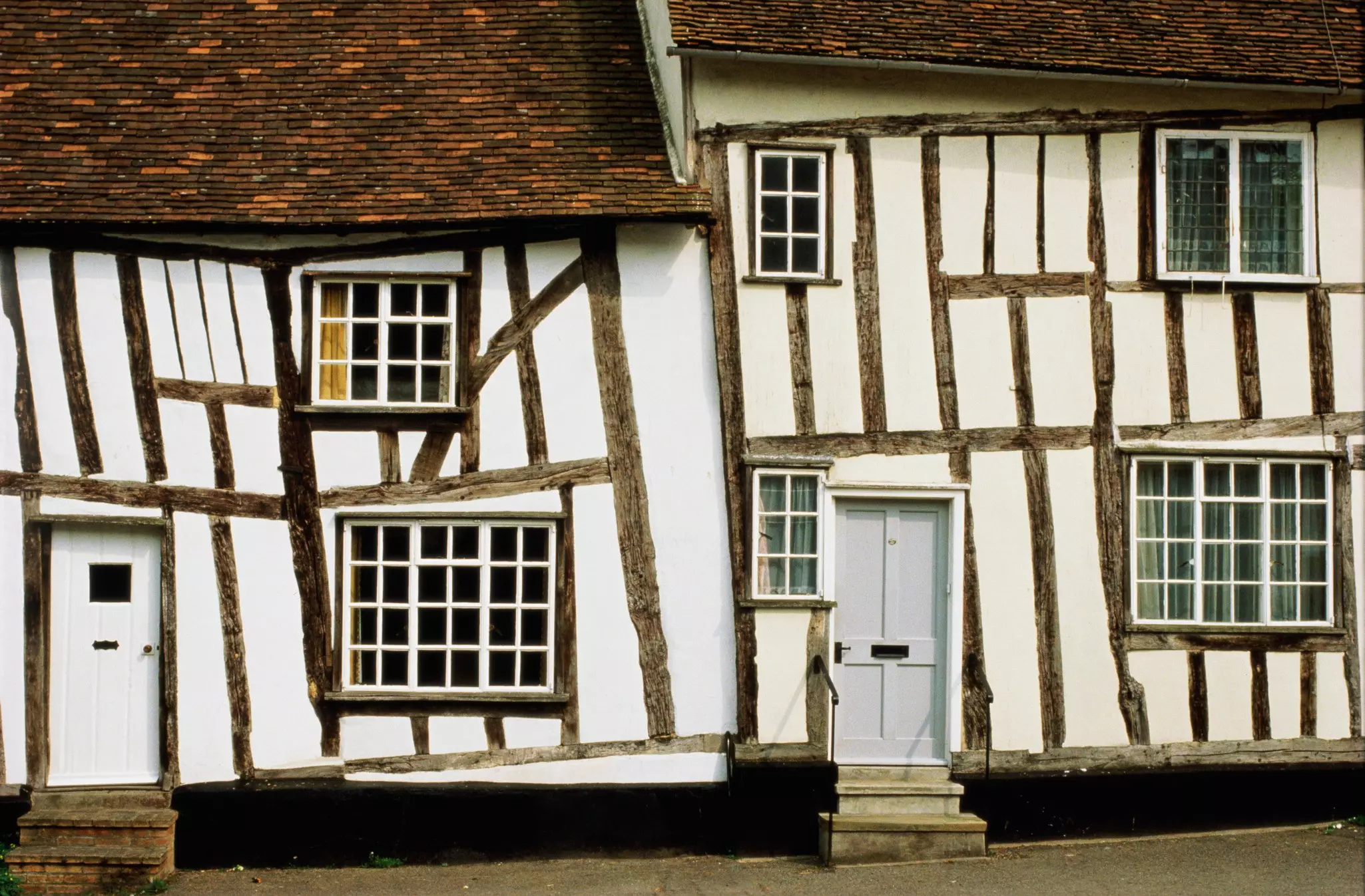 Two crooked timber-framed white houses in Levanham, England