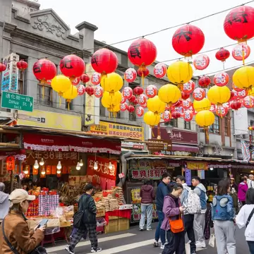 Busy Dihua Street decorated with red and yellow lanterns during the Chinese New Year in Taipei, Taiwan.