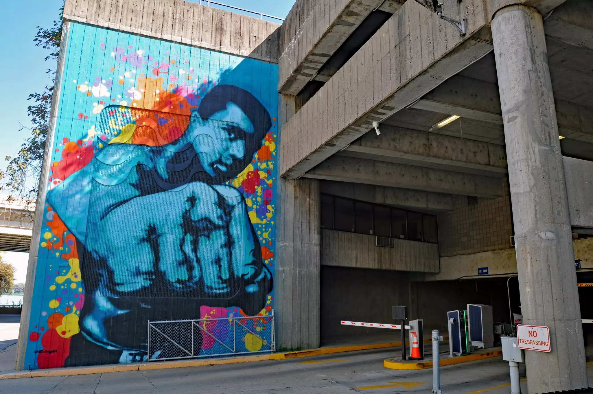 A colorful mural of boxer Muhammad Ali on the wall of a parking garage.