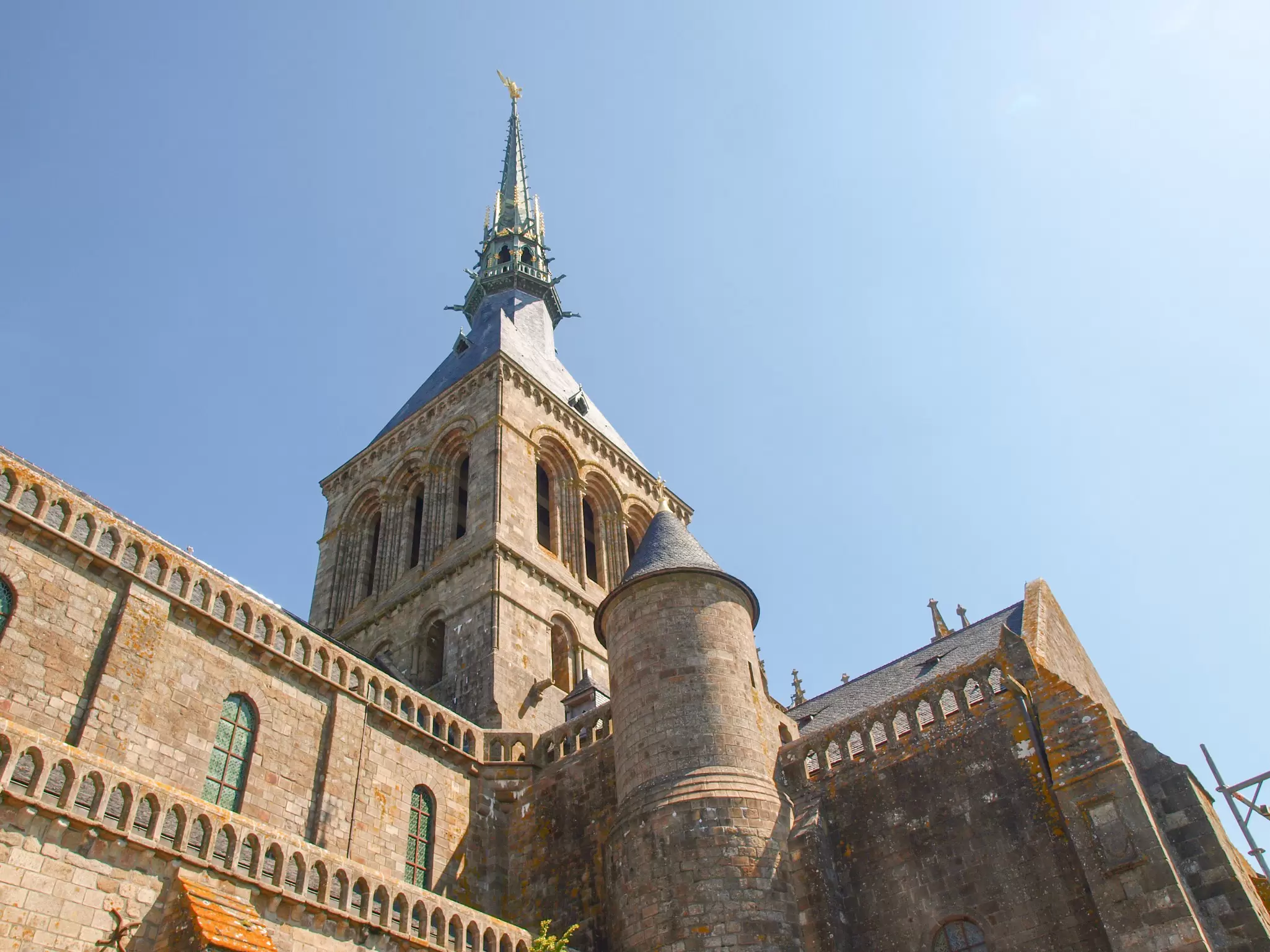 An upwards shot of a church tower with a short steeple
