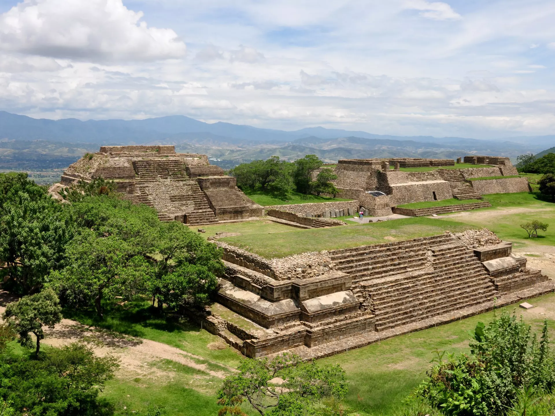The restored ruins of an ancient city, with platforms, stairways and lawns.