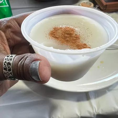 White custard, with a dusting of cinnamon, in a plastic cup.