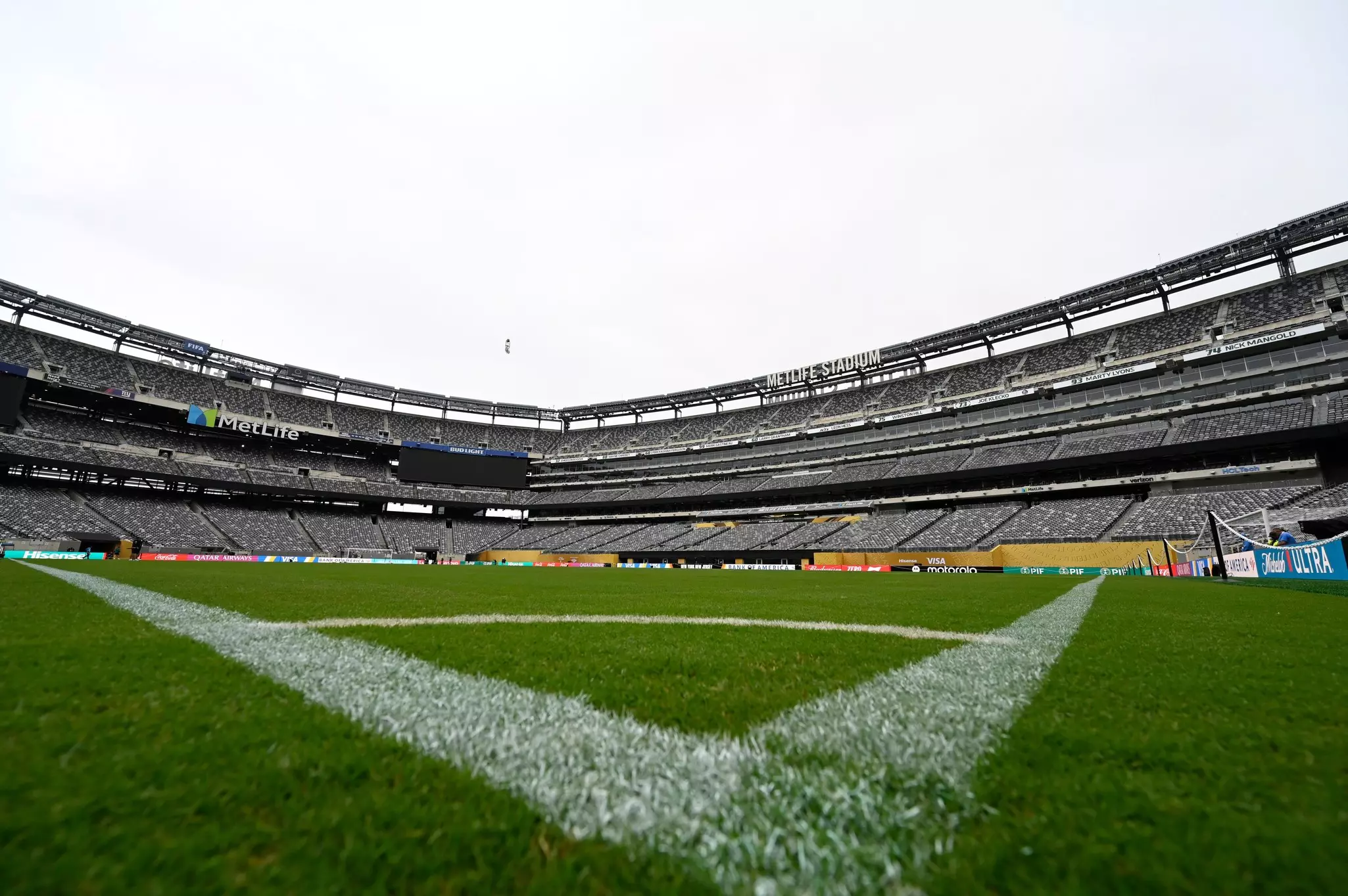 A corner of the green grass field at an empty MetLife Stadium in New Jersey configured for a FIFA match.