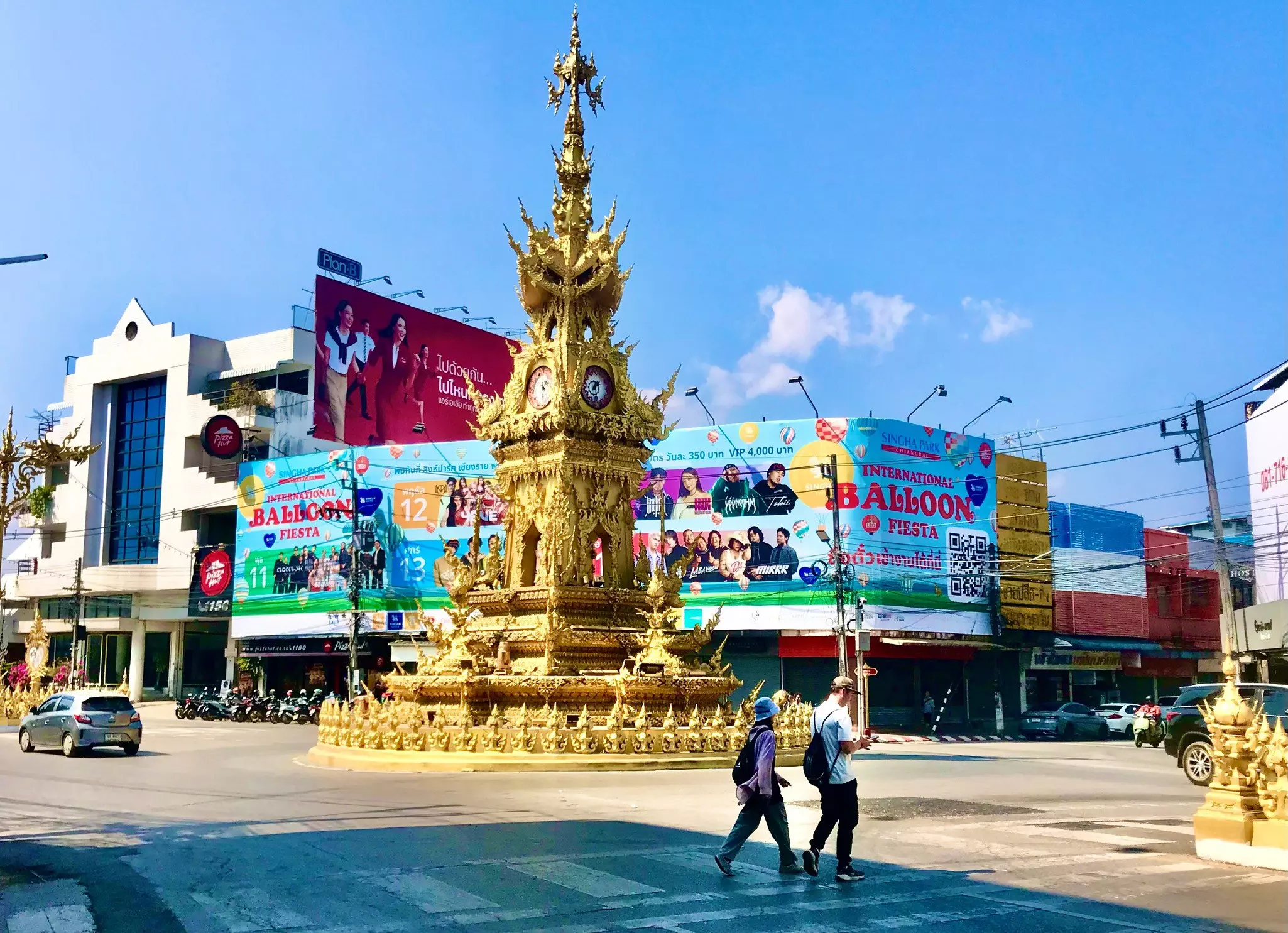 Visitors walk pas the ornamental clocktower in the center of Chiang Rai, Thailand.
