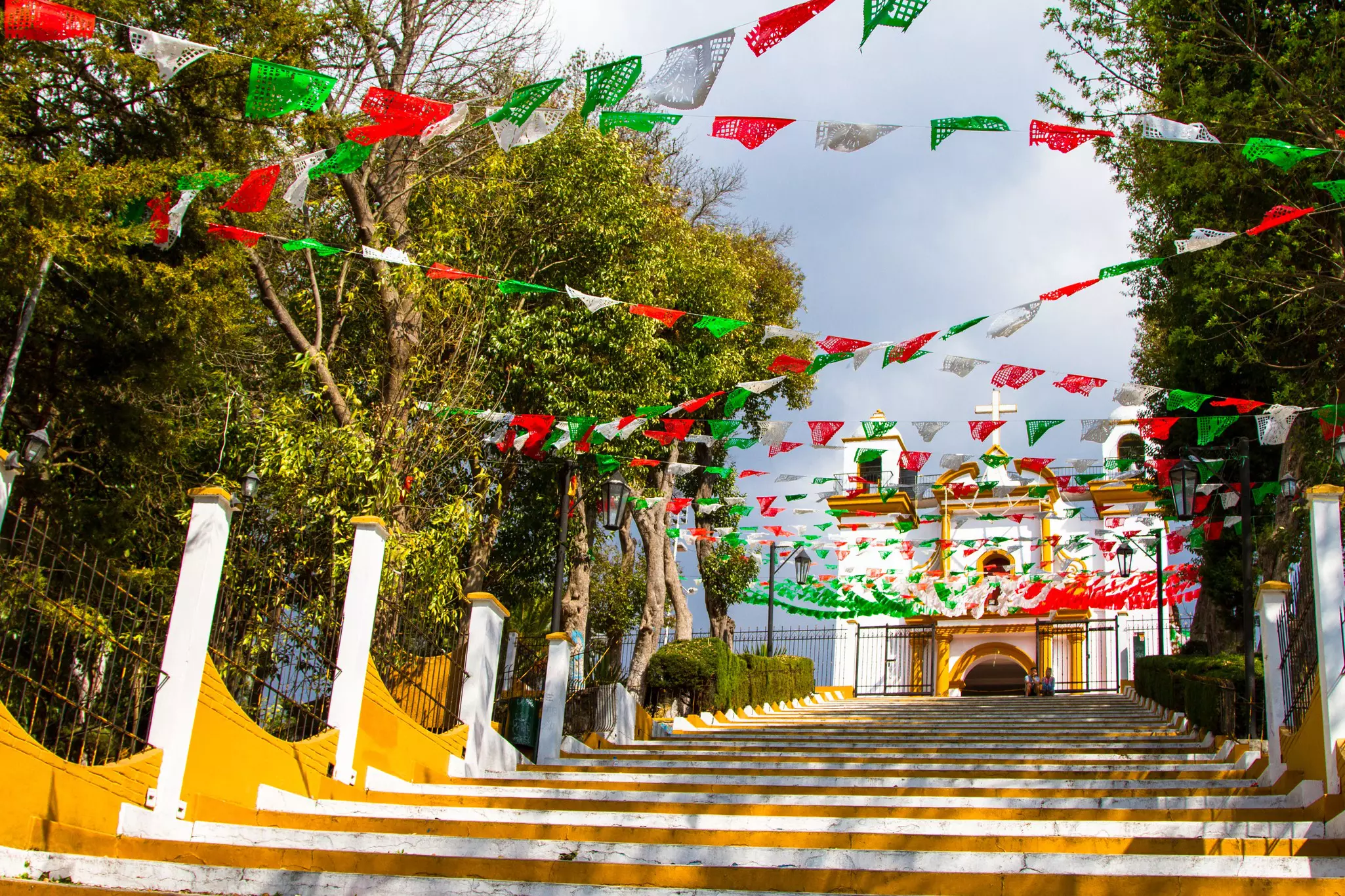Steps - with red, green and white bunting fluttering in the breeze - lead up to a small church