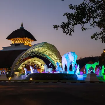 Entrance of Chiang Mai Night Safari in Chiangmai Province, Thailand after sunset with twilight light. Animal sculptures lit with neon lighting.