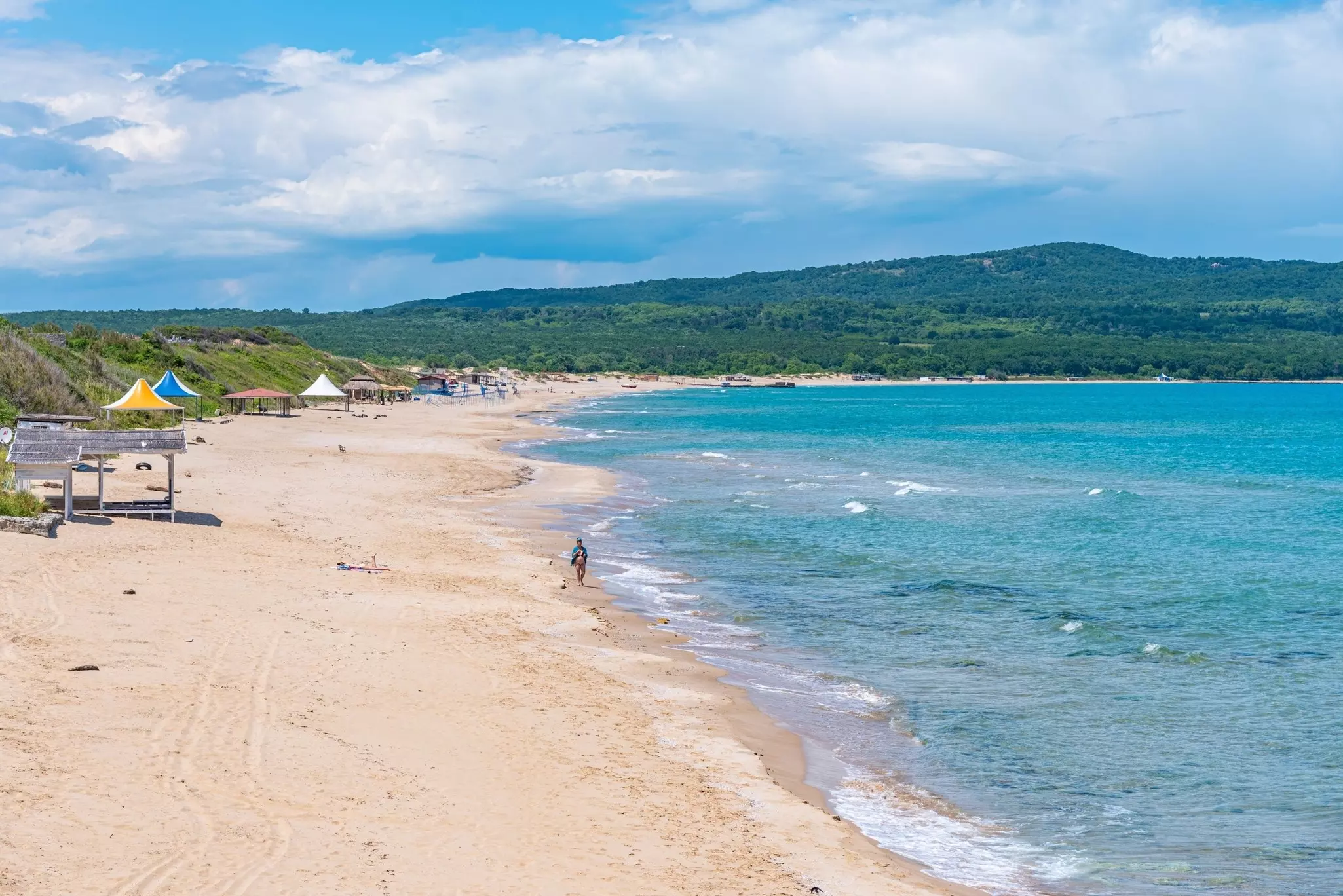 A person walking along the sand at Primorsko North Beach. 