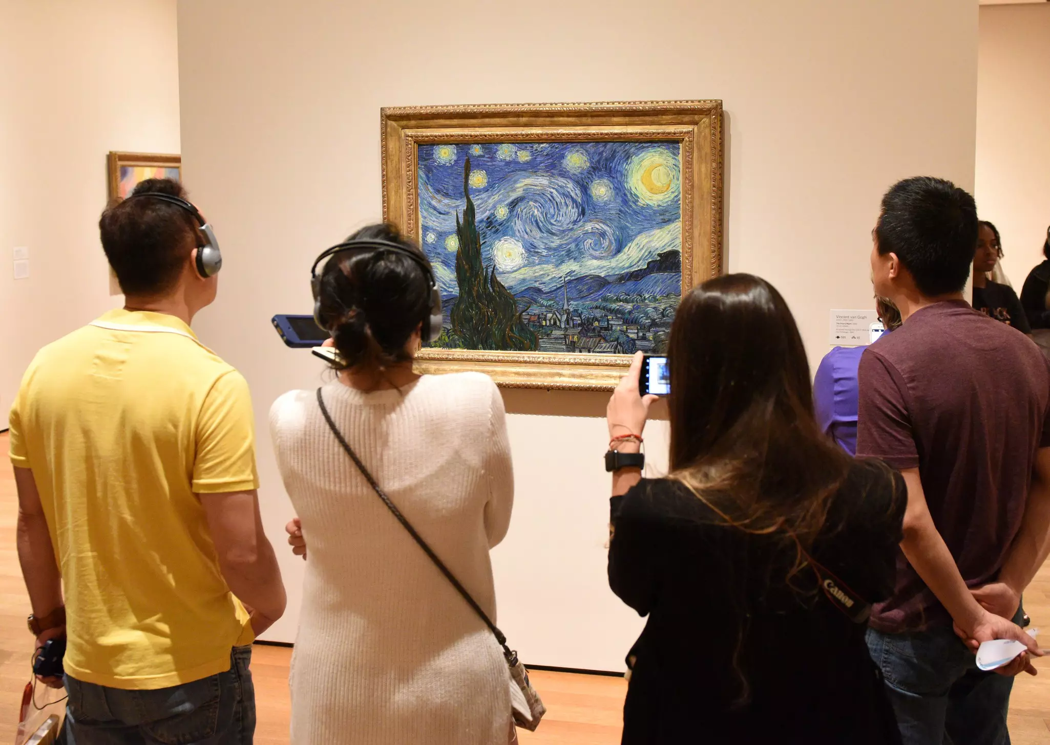 People gather to take pictures in front of “The Starry Night” by Vincent van Gogh at the Museum of Modern Art, New York City