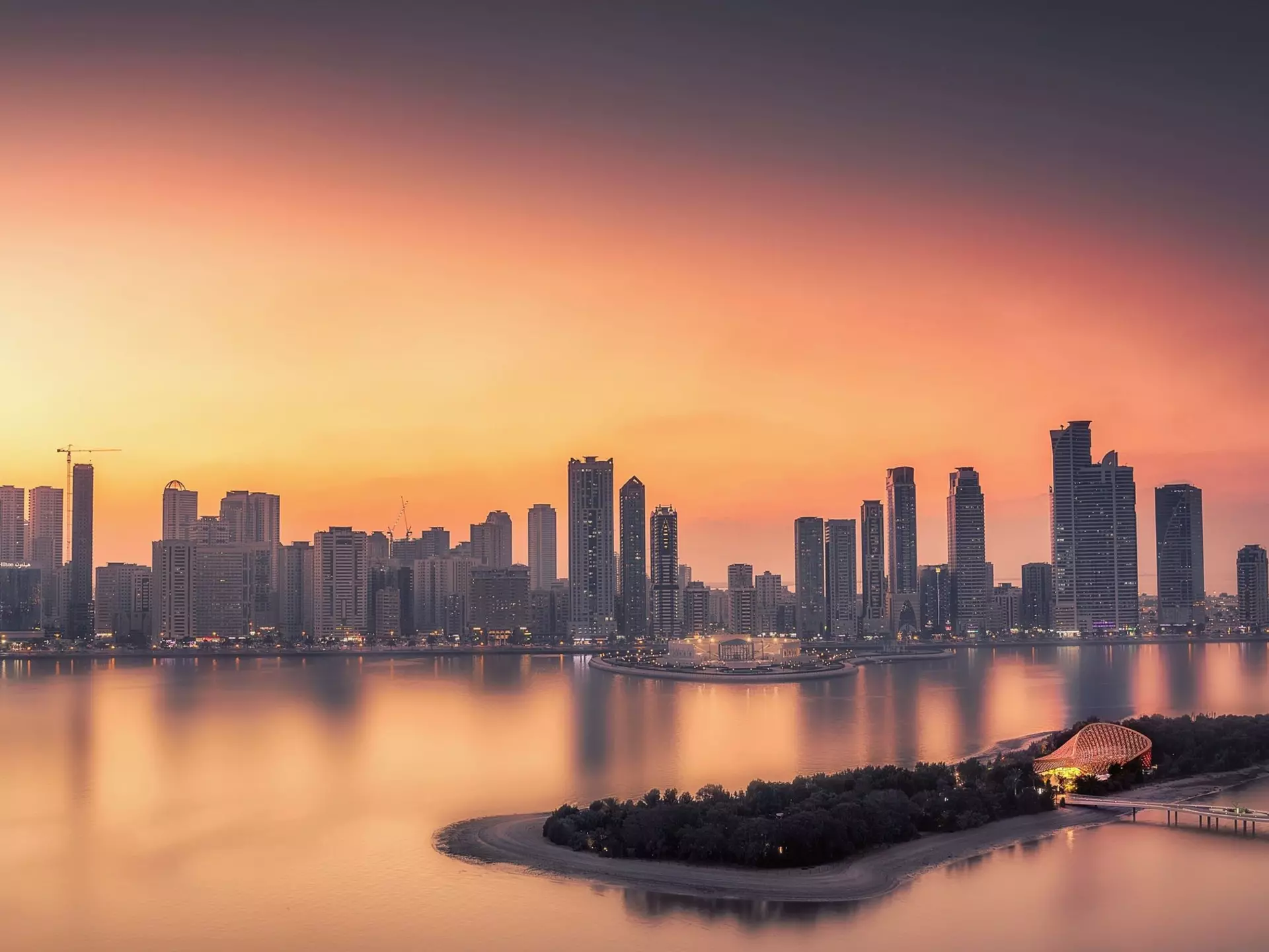 Sharjah skyline at sunset with Al Noor Island in the foreground. Bdalzyz Mmd / EyeEm / Getty Images