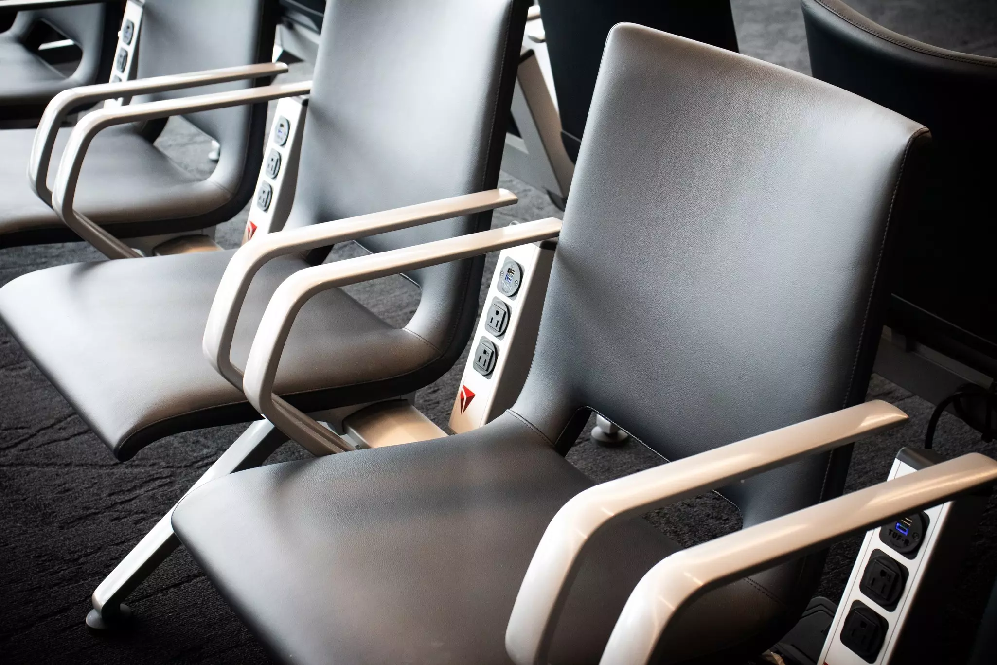 Faux leather chairs and electrical charging stations sit at a Delta Airlines gate in the renovated state-of-the-art LaGuardia airport.