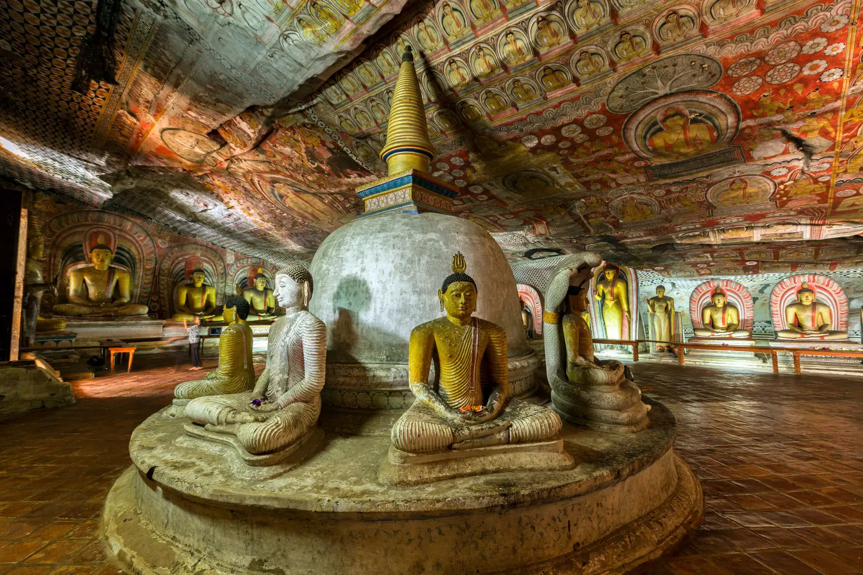 Buddha statues and colorful religious art in dimly lit caves.