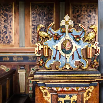 Detail of pew with rich ornate  colorful woodwork in the chapel of Kronborg Slot castle in Helsingor, Denmark.
