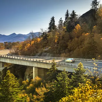 Cars travel on the Linn Cove Viaduct along the Blue Ridge Parkway in fall, North Carolina