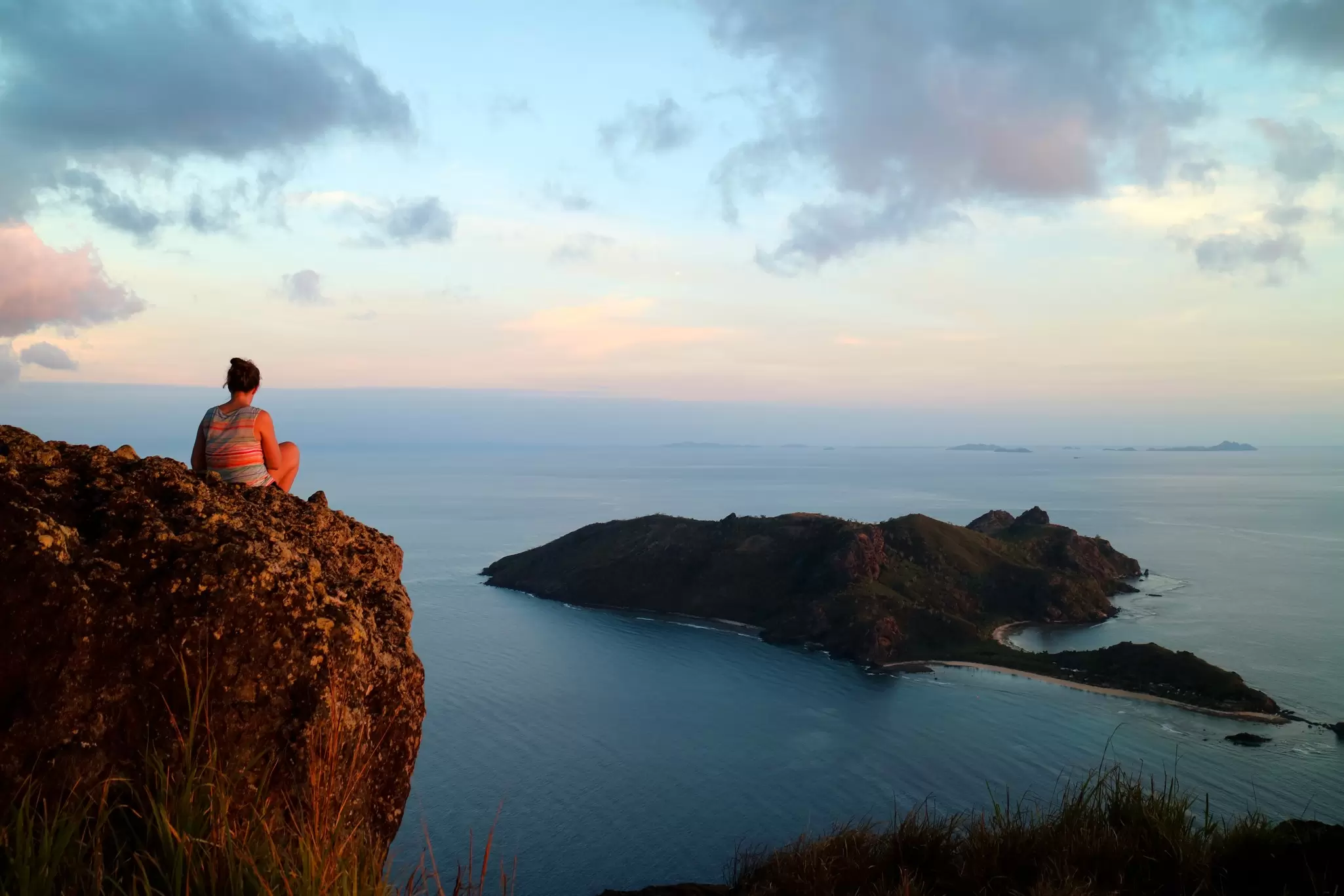 Woman overlooking stunning view over the sea from a rock on a high point in Yasawa, Fiji. Sara Petersson / Shutterstock