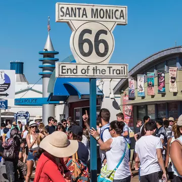 Santa Monica, California, USA - July 22, 2016: Tourists visit the Santa Monica Pier, the "End of the Trail" of the famous Route 66.  License Type: media  Download Time: 2023-06-14T12:16:09.000Z  User: dermothegarty77  Is Editorial: Yes  purchase_order: 56530  