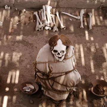 Mummified human remains surrounded by bones at Chauchilla Cemetery, Peru.