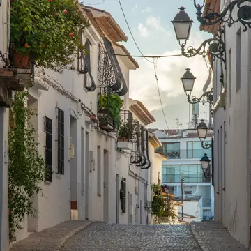 View of the narrow cobblestone street with whitewashed houses in an old town part of Altea resort town on Costa Blanca, Spain, License Type: media, Download Time: 2025-02-24T16:04:26.000Z, User: Ppeterson948, Editorial: false, purchase_order: 56530 - Guidebooks, job: Global Publishing WIP, client: Global Publishing WIP, other: Pia Peterson Haggarty