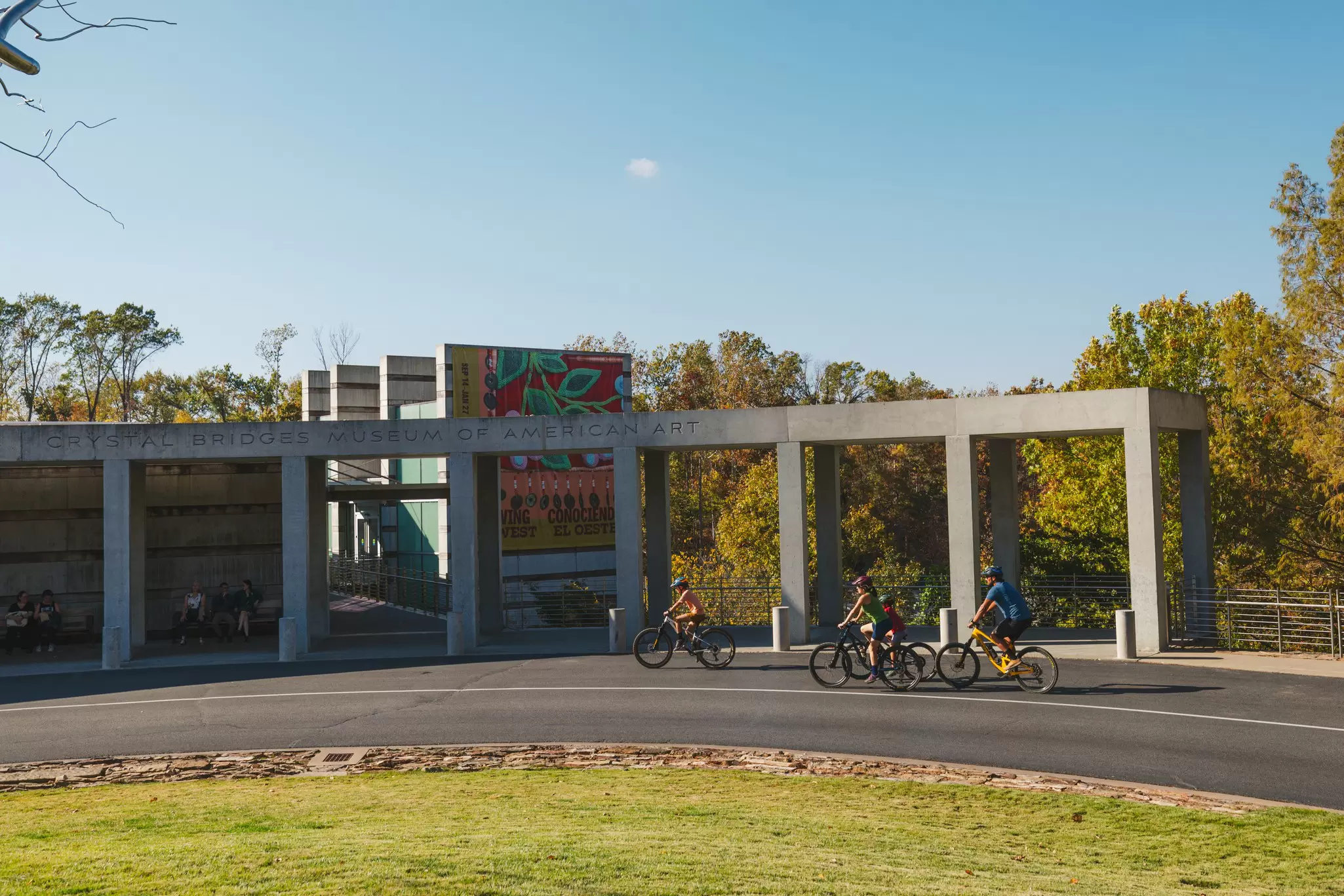 People cycling by a large museum.