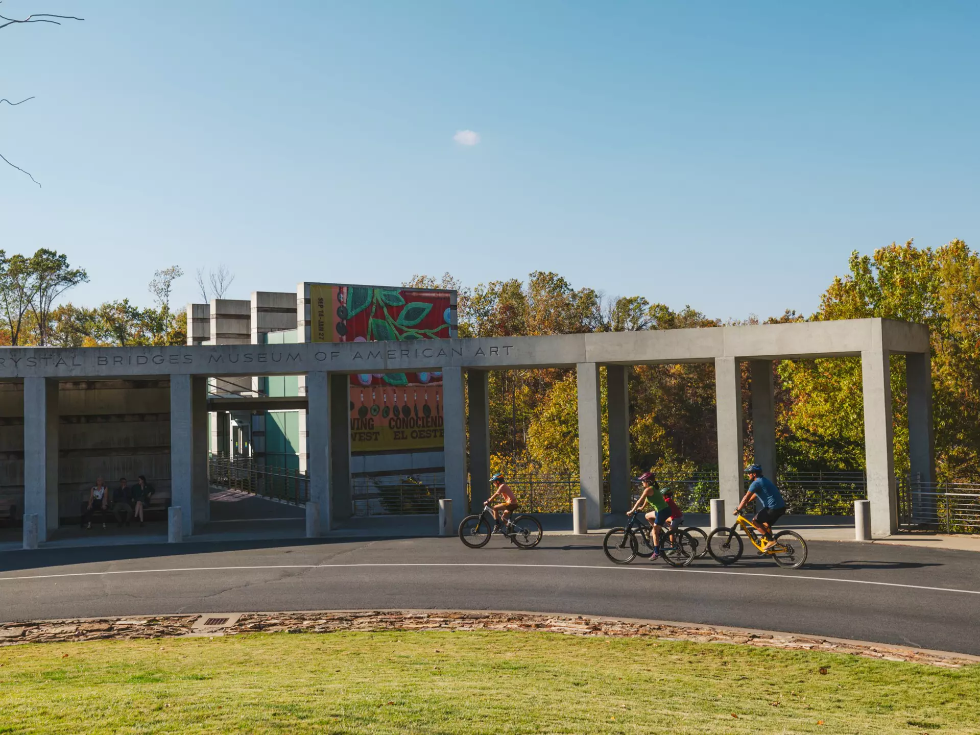 People cycling by a large museum.