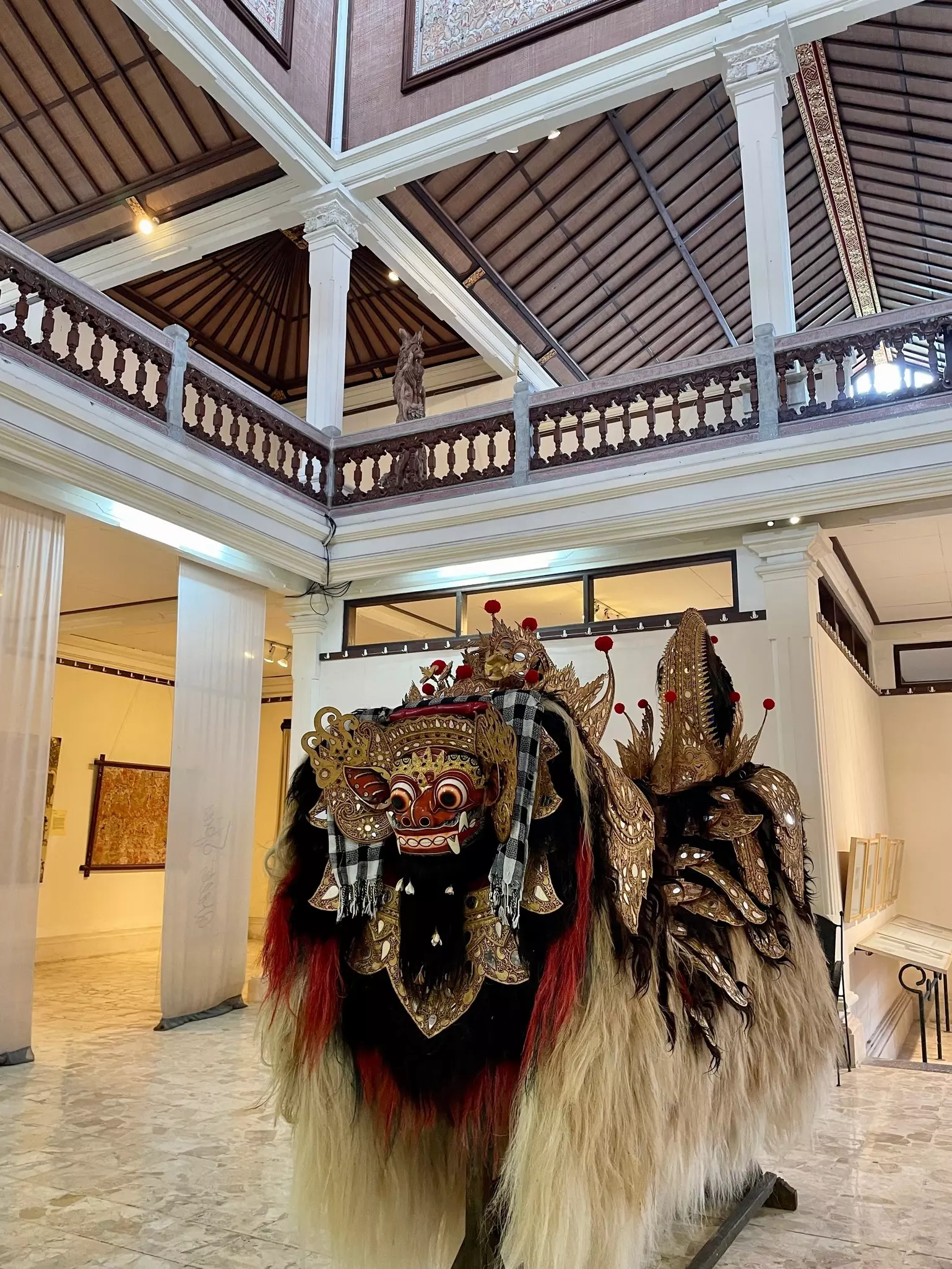 A traditional tiger costume is on display in the atrium of a museum.