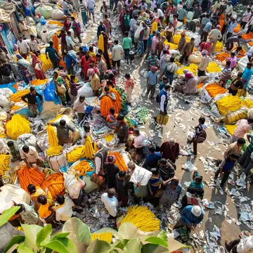 Overhead view of customers and traders at the huge Mullik Ghat Flower Market. Kolkata, West Bengal, India.