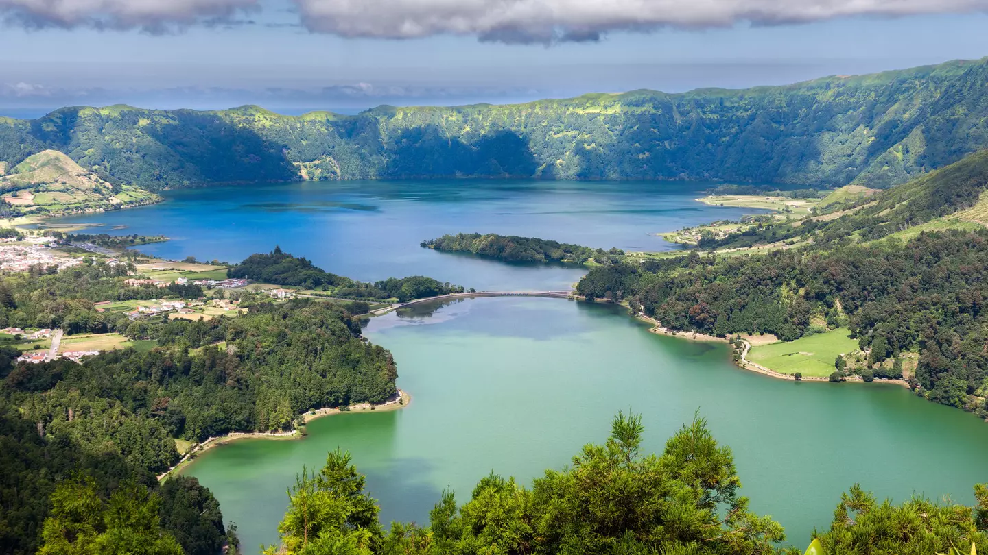 A series of clouds overlooks twin blue and green lakes of Lake  Sete Cidades from Vista do Rei viewpoint in Sao Miguel, Azores.