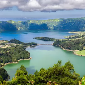 A series of clouds overlooks twin blue and green lakes of Lake  Sete Cidades from Vista do Rei viewpoint in Sao Miguel, Azores.