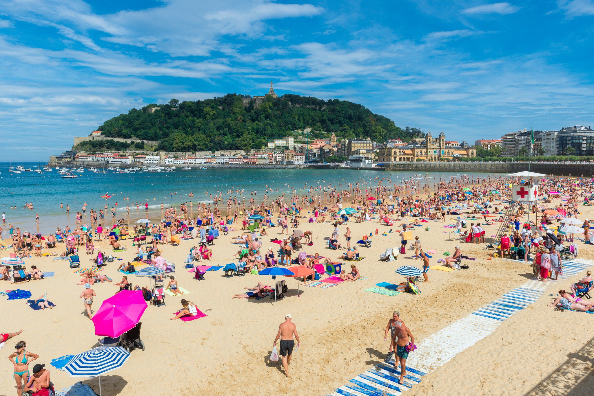 People swimming and tanning on Playa de la Concha in San Sebastián, Spain.