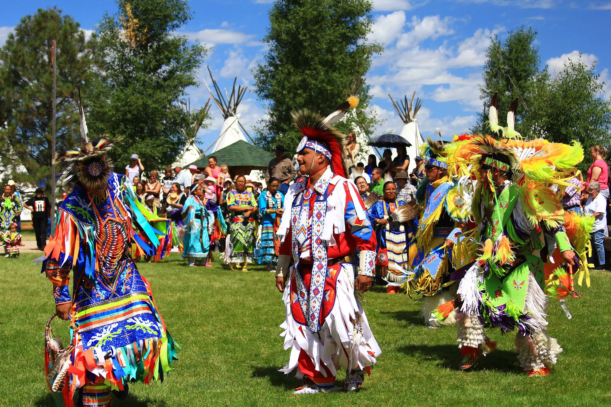 Native American performers in costume dance at a pow-wow.