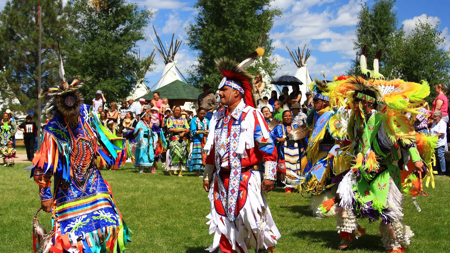 Native American performers in costume dance at a pow-wow.